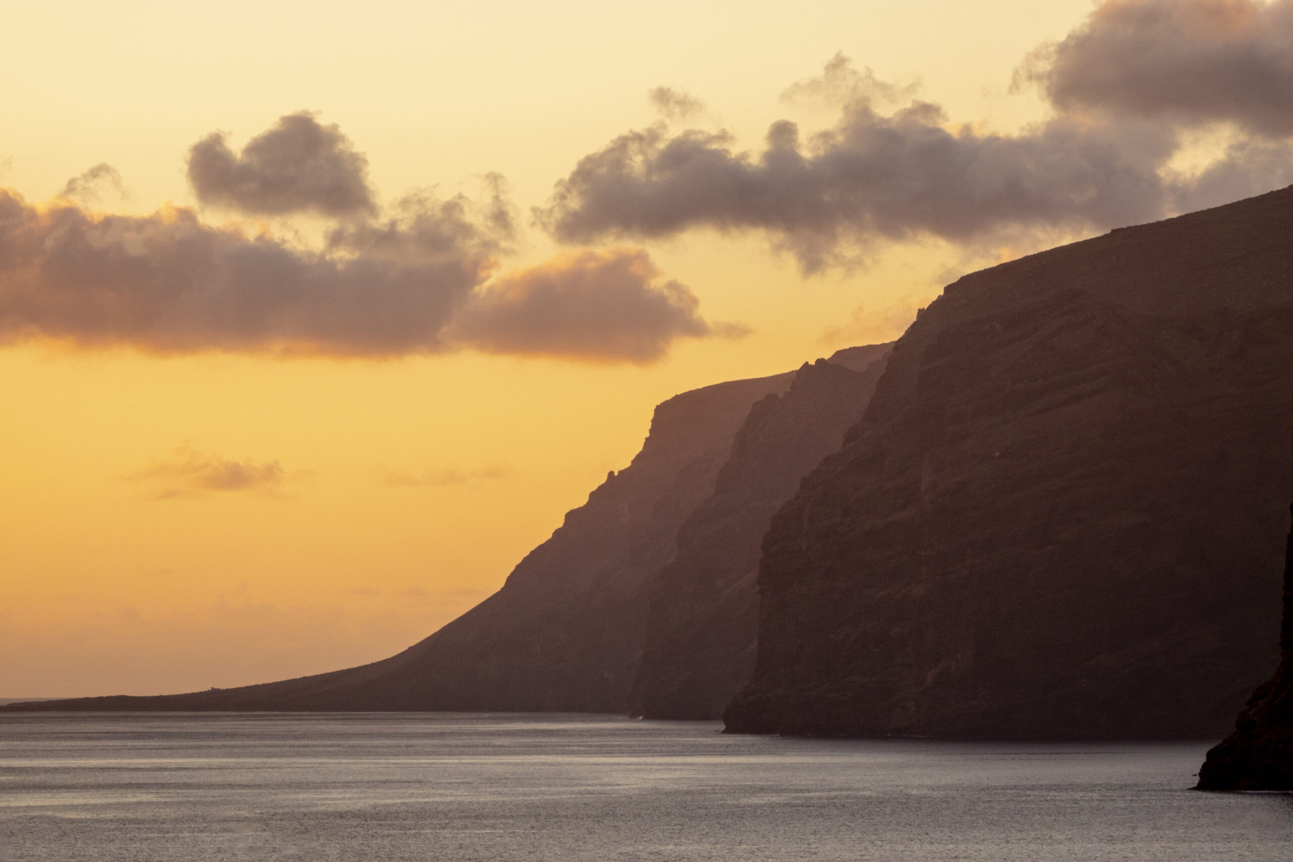 Falaises méditerranéennes dorées au coucher du soleil — image de solitude apaisée et d’ancrage intérieur en expatriation